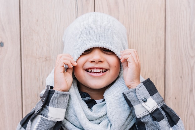 Foto grátis garotinho, cobrindo os olhos com boné de inverno