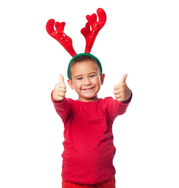 garotinho de Natal com polegares acima