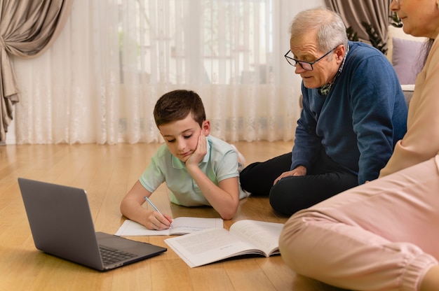 Garotinho fazendo lição de casa com o avô em casa