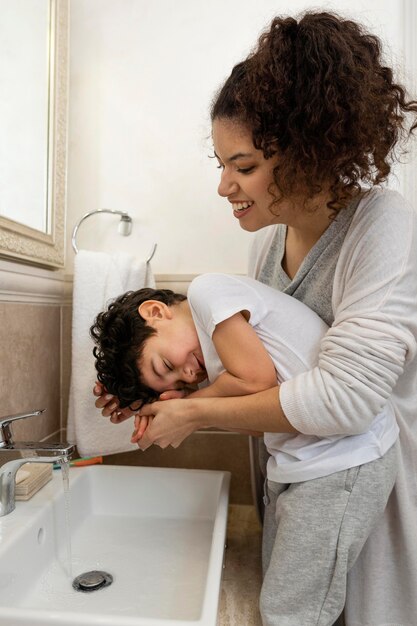 Garotinho lavando as mãos com a mãe