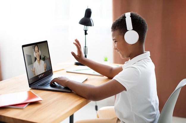 Foto grátis garotinho ouvindo a professora pelos fones de ouvido