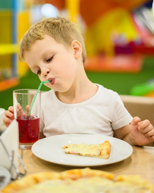 Garoto adorável bebendo suco