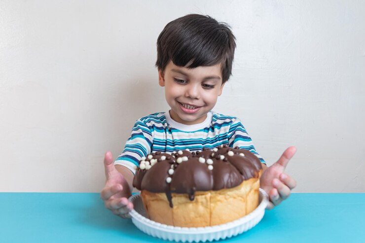 Foto grátis garoto adorável no estúdio comendo bolo de chocolate