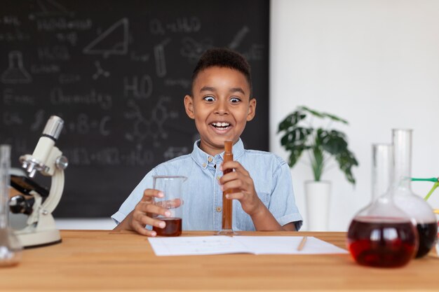 Garoto aprendendo mais sobre química na aula