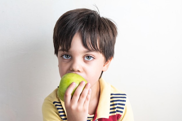 Garoto bonito comendo maçã verde