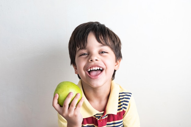 Garoto bonito comendo maçã verde