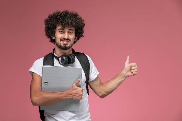 Garoto bonito de frente para a pasta com fone de ouvido e bolsa