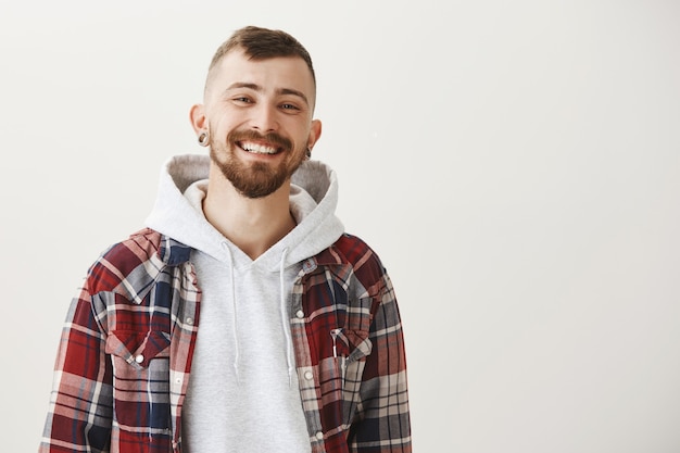 Foto grátis garoto bonito feliz com barba sorrindo satisfeito