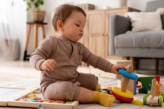 Garoto brincando com carros de madeira tiro completo