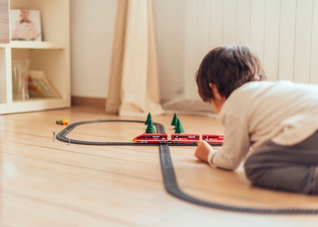 Foto grátis garoto brincando com trem de brinquedo