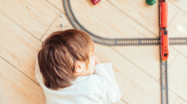 Foto grátis garoto brincando com trem de brinquedo