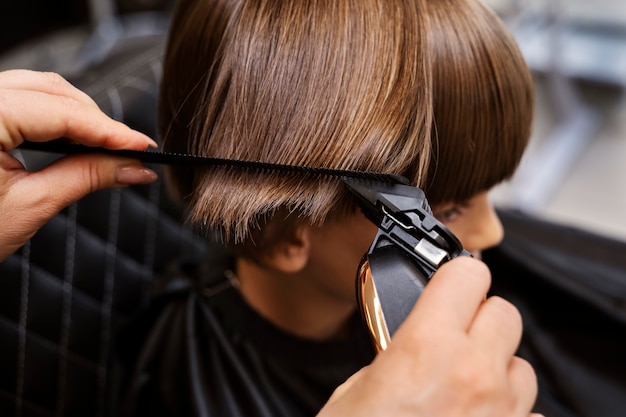Foto grátis garoto cortando o cabelo no salão de alto ângulo
