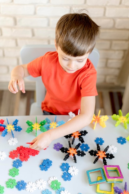 Foto grátis garoto de alto ângulo com brinquedos florais