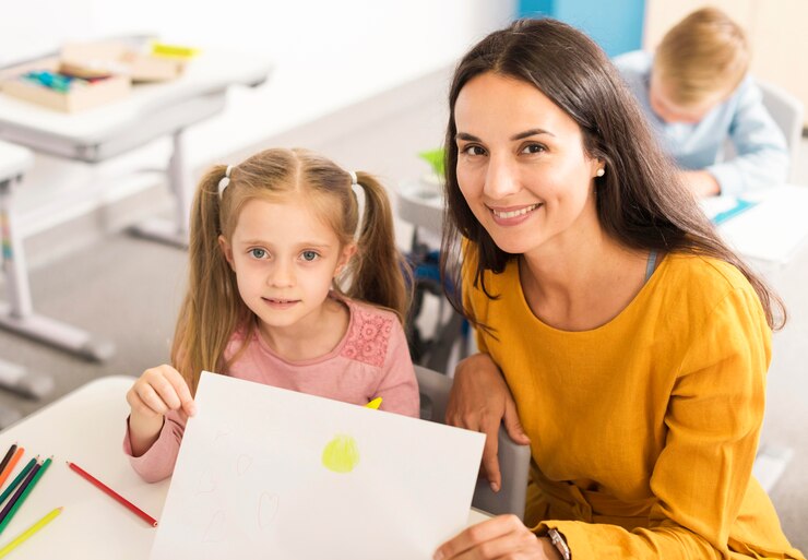 Foto grátis garoto de alto ângulo mostrando seu desenho com o professor