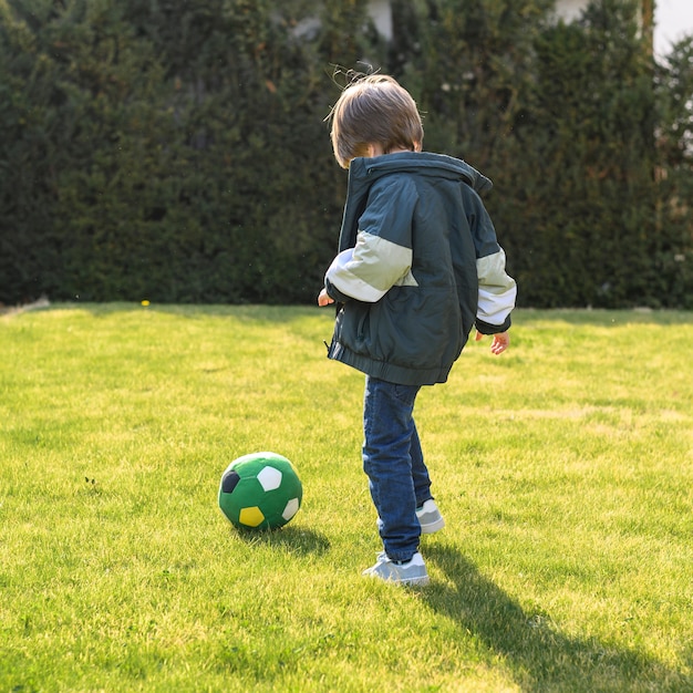 Garoto de tiro completo brincando com bola