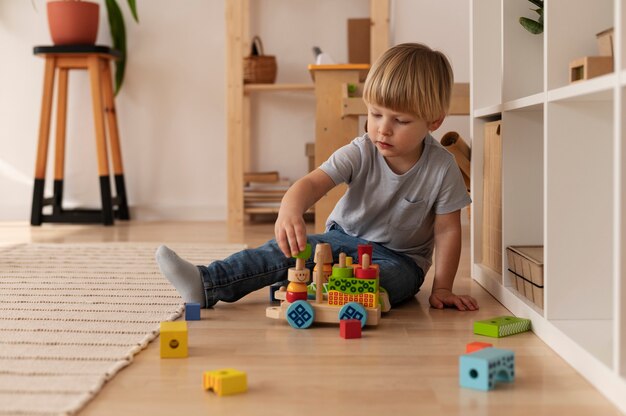 Garoto de tiro completo brincando com brinquedo de madeira em casa