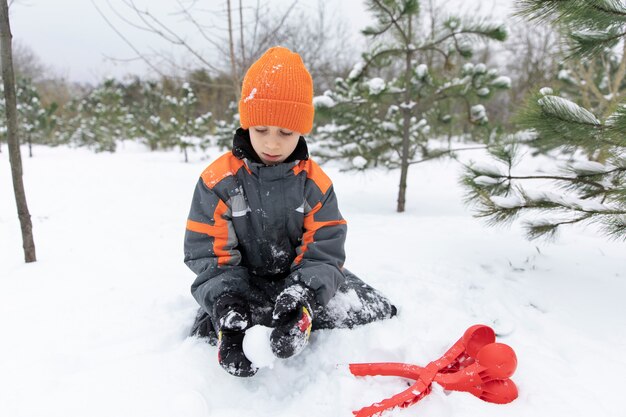 Garoto de tiro completo brincando com neve