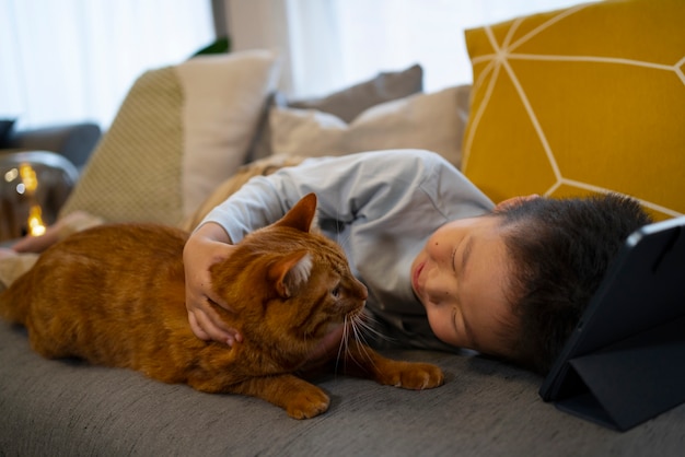 Foto grátis garoto de tiro completo com gato fofo