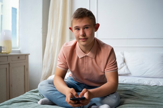 Garoto de tiro completo com síndrome de down na cama