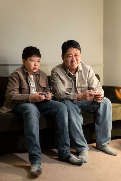 Foto grátis garoto de tiro completo e homem jogando videogame