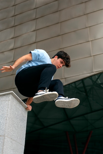 Foto grátis garoto de tiro completo fazendo parkour