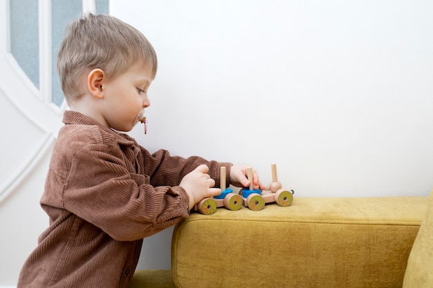 Foto grátis garoto de tiro médio brincando com madeira