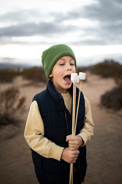 Foto grátis garoto de tiro médio comendo marshmallows