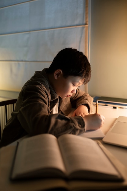 Foto grátis garoto de tiro médio fazendo lição de casa