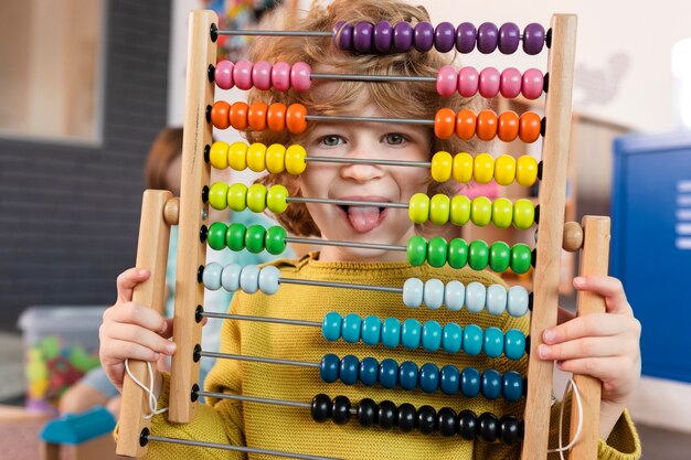 Garoto de tiro médio segurando o brinquedo de madeira