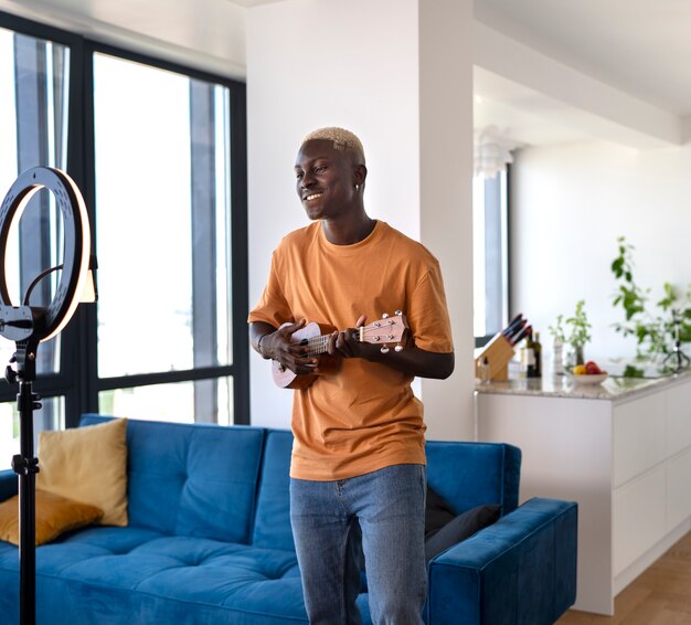 Foto grátis garoto de vista lateral tocando ukulele