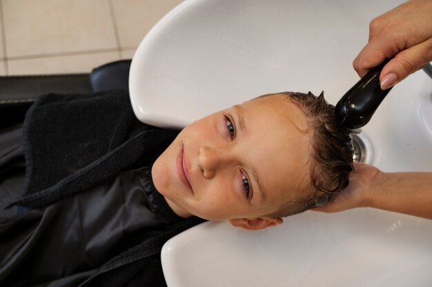 Garoto de vista superior lavando o cabelo no salão