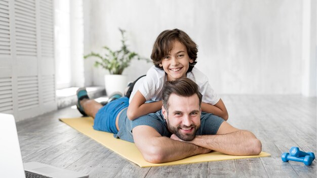 Garoto e seu pai fazendo esporte em casa