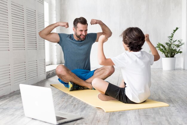 Garoto e seu pai fazendo esporte em casa