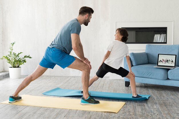 Garoto e seu pai fazendo esporte em casa