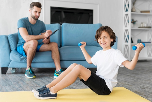 Garoto e seu pai fazendo esporte em casa