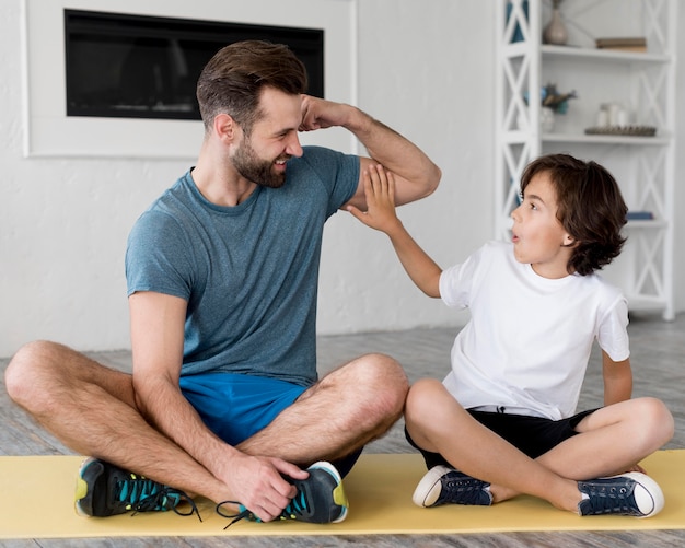 Garoto e seu pai fazendo esporte em casa