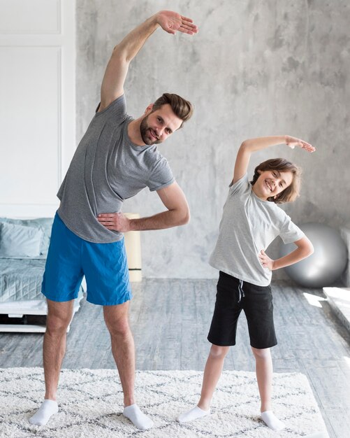 Garoto e seu pai fazendo esporte em casa