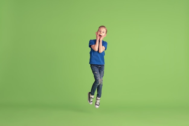 Foto grátis garoto feliz brincando e se divertindo com as emoções da parede verde