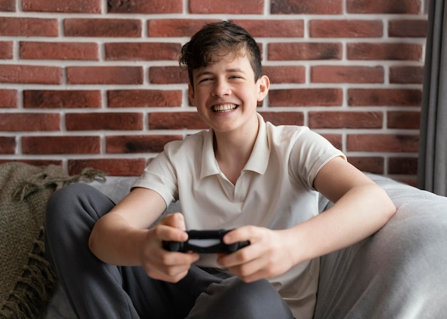 Foto grátis garoto feliz jogando videogame médio tiro