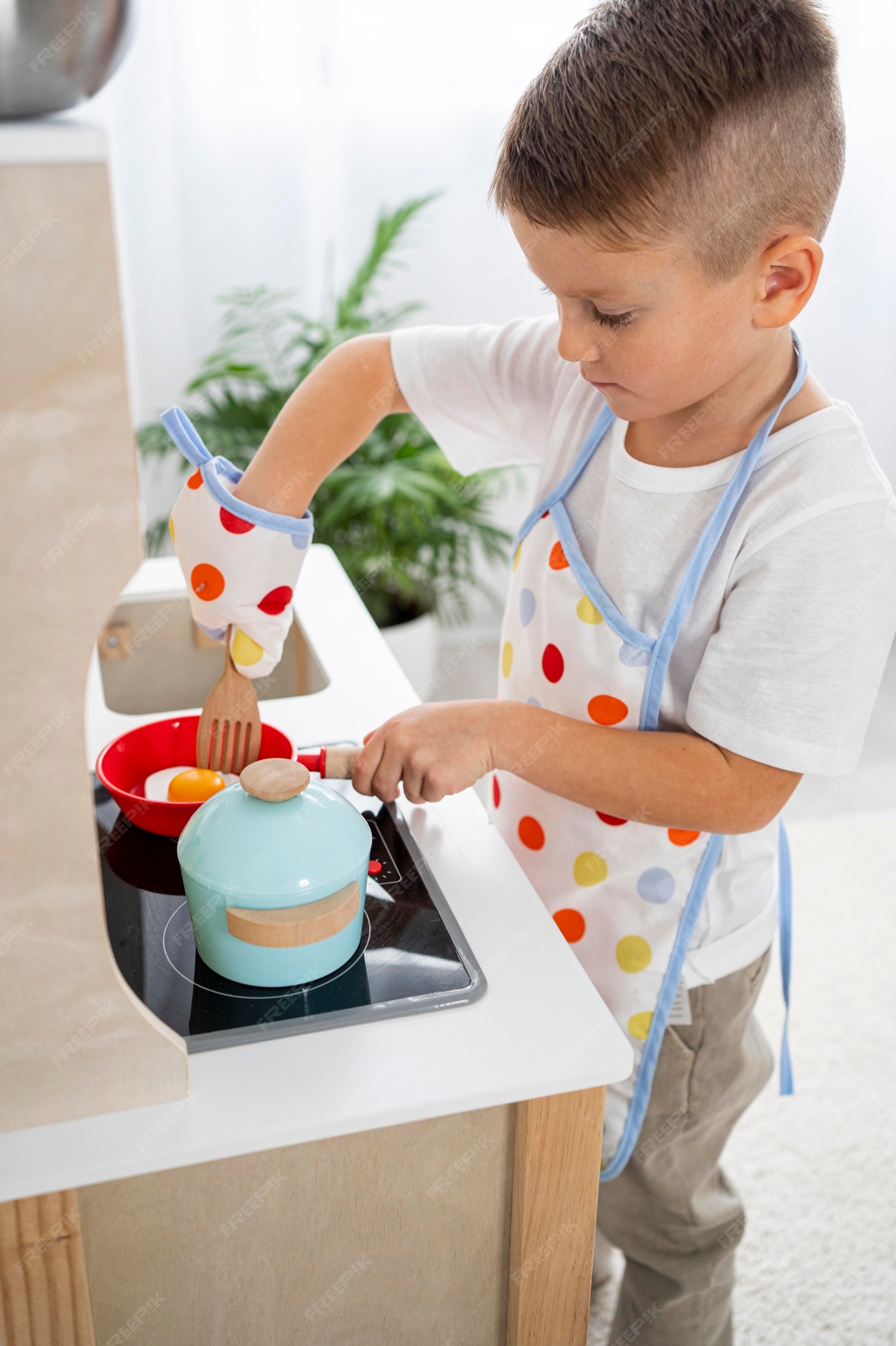 Menino brincando com um jogo de culinária dentro de casa