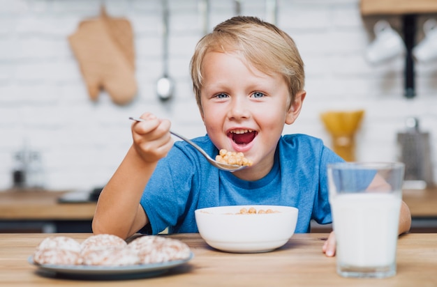 Garoto sorridente comendo cereal