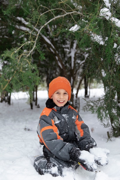 Garoto sorridente de tiro completo segurando neve