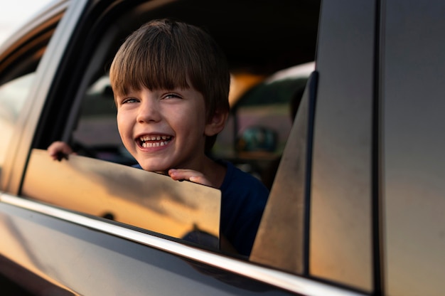 Garoto sorridente na janela do carro