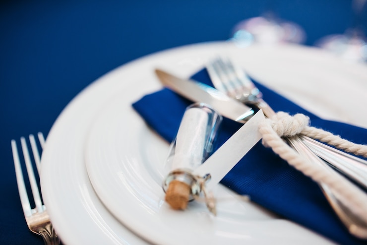 Foto grátis garrafa com uma carta encontra-se no guardanapo azul na mesa de jantar