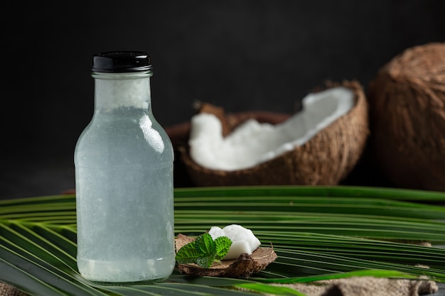 Garrafa de água de coco colocada em fundo escuro