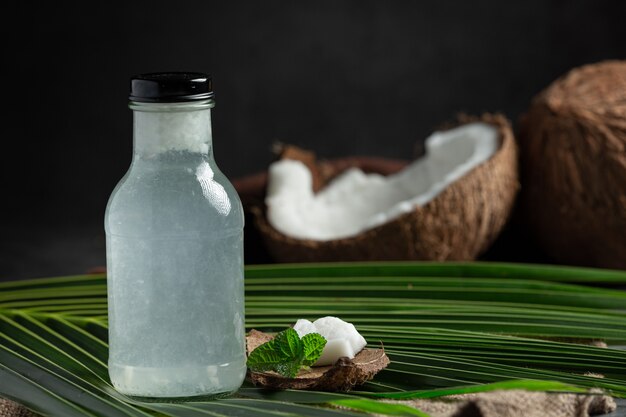 garrafa de água de coco colocada em fundo escuro