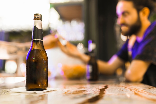 Foto grátis garrafa de álcool no papel de tecido sobre a mesa de madeira