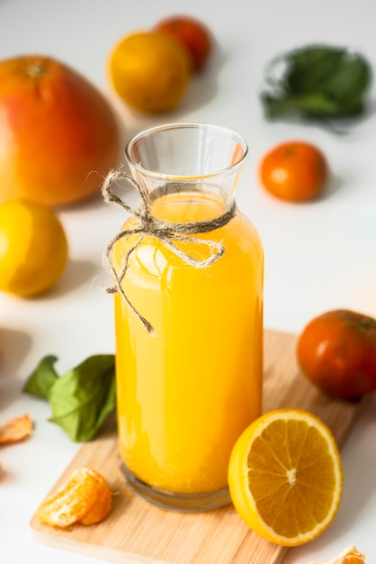 Foto grátis garrafa de ângulo alto com suco de laranja