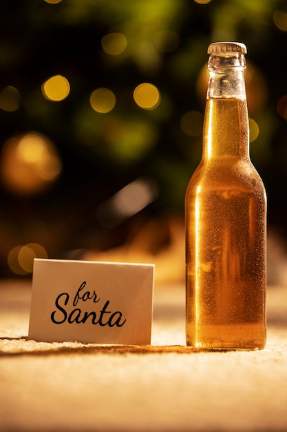 Foto grátis garrafa de cerveja de natal e nota ainda vida