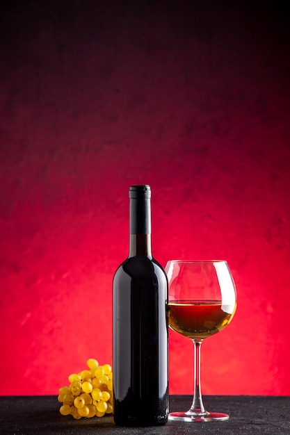 Garrafa de vinho de uvas amarelas de vista frontal em vidro com fundo vermelho